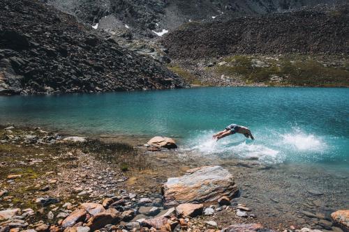 a person jumping into a body of water at Glanz & Glory Appartements Sölden in Sölden