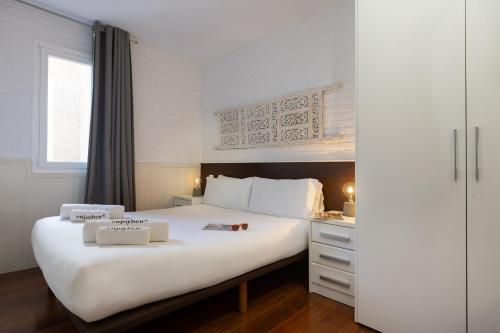 a bedroom with a large white bed and a window at Enjoybcn Gaudi Apartments in Barcelona