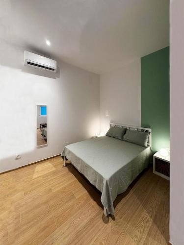 a bedroom with a bed and a green and white wall at Appartamento Bianca in Prato