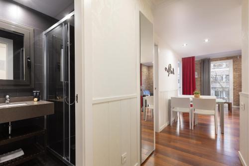 a bathroom with a sink and a dining room at Enjoybcn Gaudi Apartments in Barcelona