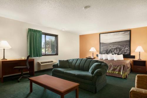 a hotel room with a bed and a couch at Super 8 by Wyndham Concordia in Concordia