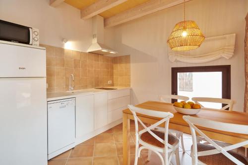 a kitchen with a wooden table and white cabinets at Son Rossinyol Nou - Sa Bovera in Campos