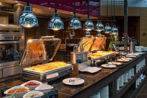 a buffet line with plates of food and lights at Park Inn by Radisson Berlin Alexanderplatz in Berlin