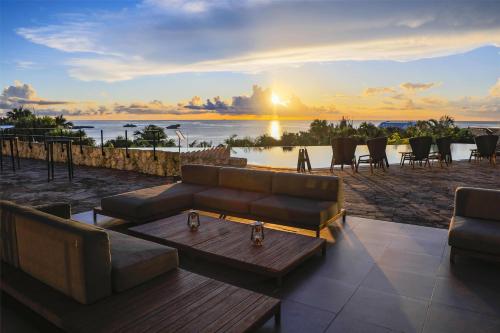 a living room with a couch and a table and a sunset at Hyatt Regency Seragaki Island Okinawa in Onna