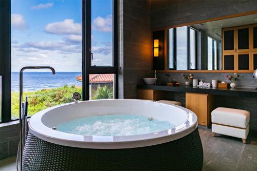 a bath tub in a bathroom with a view of the ocean at Hyatt Regency Seragaki Island Okinawa in Onna