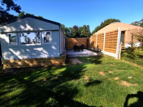 a tiny house in a yard next to a fence at Magnolia in Cambron-Casteau