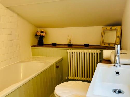 un bagno con lavandino, WC e vasca di Quarry Cottage - Snug Hideaway a Box