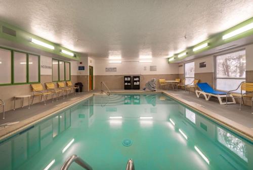 a large swimming pool with chairs and tables in a building at Wingate by Wyndham Great Falls in Great Falls