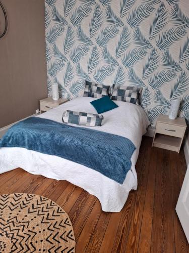 ein Schlafzimmer mit einem Bett mit einer blauen Decke in der Unterkunft la villa mersoise in Mers-les-Bains