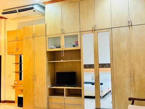 a living room with wooden cabinets and a television at สวนไมตรีจิต รีสอร์ท in Ban Khlong Si