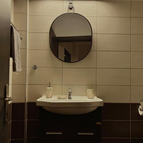 un baño con lavabo y espejo en Anemelia Apartments-Port, en Thassos
