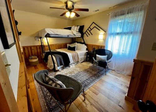 a bedroom with a bunk bed and chairs and a ceiling fan at Sky High by Carolina Mornings in Swiss