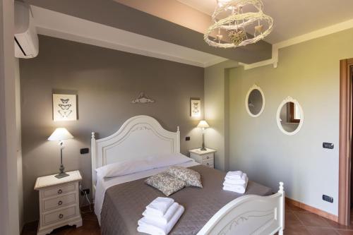 a bedroom with a white bed and a chandelier at CS Holiday in Castelnuovo Berardenga