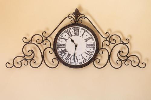 a clock is hanging on a wall at CS Holiday in Castelnuovo Berardenga