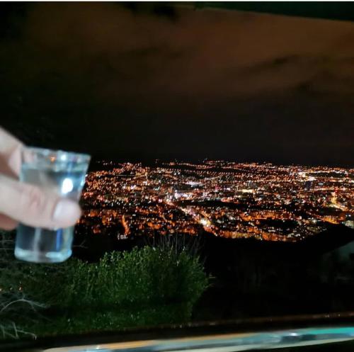 a person holding a glass of water at night at Ranč Vranješ in Banja Luka