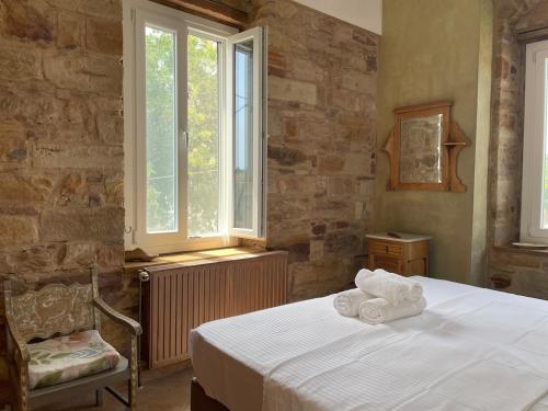 a bedroom with a bed with towels on it at Kampos Mansion 1 in Chios