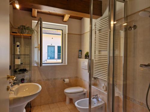 a bathroom with a toilet and a sink and a shower at Maisonnette terrace in Lierna