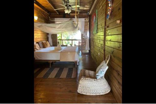a bedroom with a bed and a chair in a room at Cabarete Ecolodge Encuentro Surf Beach Kite in Perla Marina by BTCG Crypto in Bombita