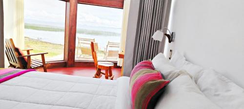 a bedroom with a bed and a view of the ocean at Luquina Experience Lodge in Luquina