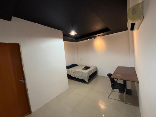a small room with a bed and a table in it at Hotel e Restaurante Casa Paraense Original, px ao aeroporto in Manaus