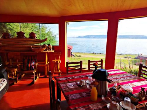 a dining room with a table and a view of the water at Luquina Experience Lodge in Luquina