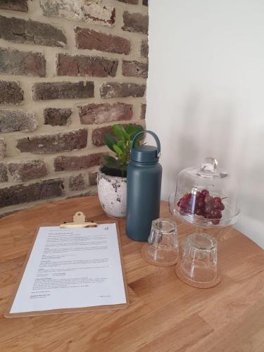 a table with a blue thermos and glasses on it at B&B Groot Haasdal in Schimmert