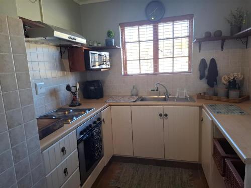a kitchen with a sink and a stove top oven at Meadow View Guest Cottage in Wakkerstroom