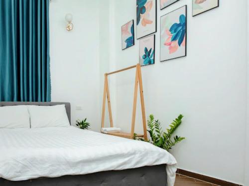 a bedroom with a bed and pictures on the wall at LALA HOUSE - CĂN HỘ Đà Lạt in Khu Chi Lăng