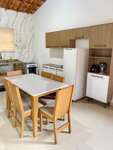 a kitchen with a table and chairs and a refrigerator at Casa Lilás no Vale do Capão in Vale do Capao