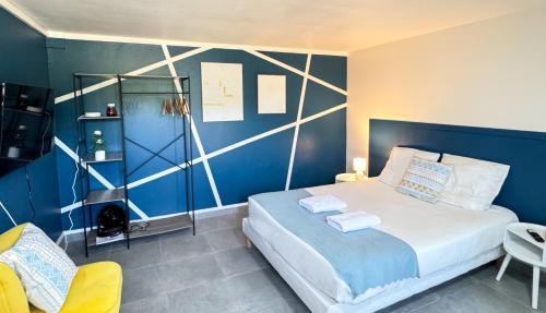 une chambre avec un lit et un mur bleu dans l'établissement Studio Platanes 9 - Proche Disneyland - Parking gratuit - Meaux, à Meaux