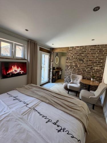 a bedroom with a large bed and a fireplace at B&B Groot Haasdal in Schimmert