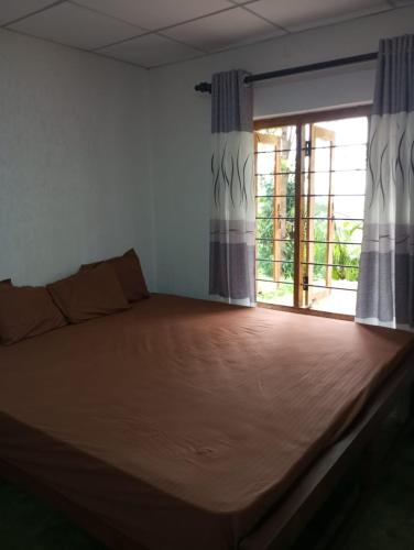 a large bed in a room with a window at Holiday Home Rathnaella in Hassalaka