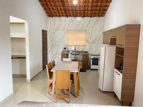 a kitchen with a table and chairs and a refrigerator at Casa Lilás no Vale do Capão in Vale do Capao
