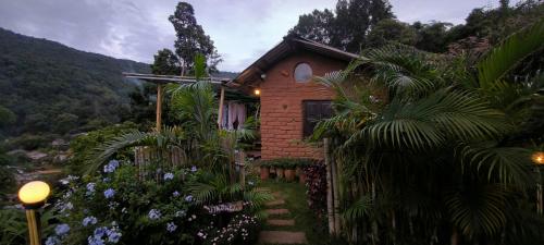 a brick house with a garden in front of it at ตั้วบ้านดิน Tuabaandin in Ban Thung Phan Ha