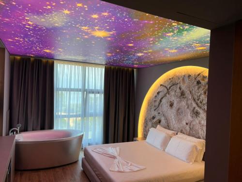 a bedroom with a bath tub and a star ceiling at Toka Hotel Restaurant in Pogradec