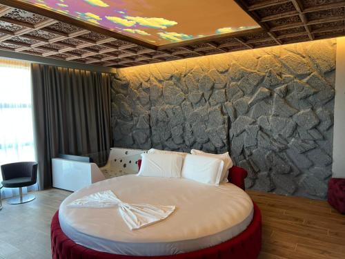 a bedroom with a large bed with a stone wall at Toka Hotel Restaurant in Pogradec
