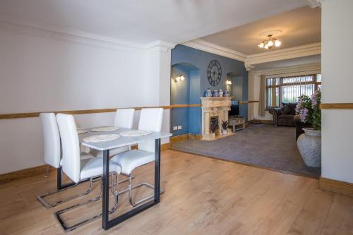 a living room with a table and chairs and a fireplace at Welbeck House, close to Swansea Central in Cockett