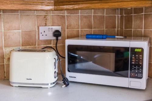 a microwave sitting on a counter next to a toaster at Welbeck House, close to Swansea Central in Cockett