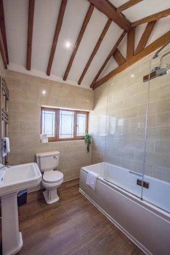 a bathroom with a toilet and a tub and a sink at Welbeck House, close to Swansea Central in Cockett