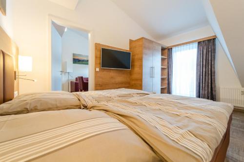 a bedroom with a bed with a tv on the wall at Apartment 311 in Feldberg