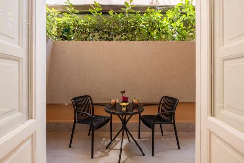 a table with three chairs and a table with drinks on it at Villa Libertà in Palermo