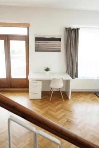 a white desk in a white room with a chair at Vilas & Wellness Resort Orlík in KozÃ¡rovice