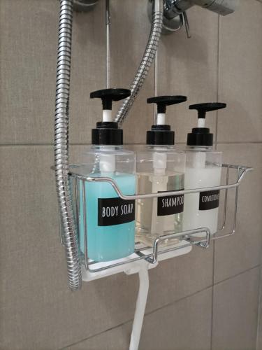 a couple of bottles of soap in a rack in a bathroom at Casa di Otti in Ivrea