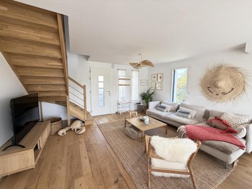 a living room with a couch and a tv at Maison neuve pour 8 - 500m plage du Rouvran in Le Tour-du-Parc