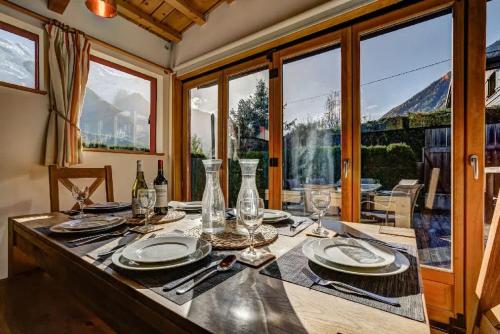 une table de salle à manger avec des assiettes et des verres dessus dans l'établissement Chalet Alpins - Central Jacuzzi Parking, à Chamonix-Mont-Blanc