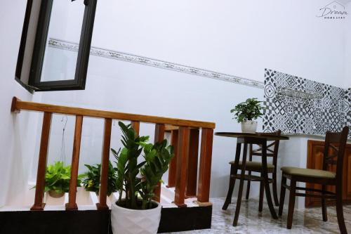 a room with a staircase with a table and some plants at Homestay Dream in Tuy Hoa