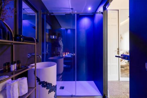 a bathroom with a glass shower with blue lighting at Villa Libertà in Palermo