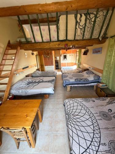 a room with three bunk beds and a table at Les Coquettes in Richerenches