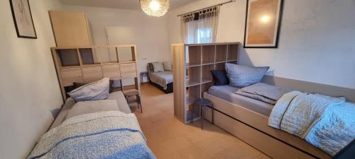 een kleine kamer met 2 bedden en een bank bij Arzberger MonteurApartment in Arzberg