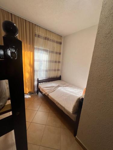 a small bedroom with a bed and a window at Hotel PEJA in Velipojë